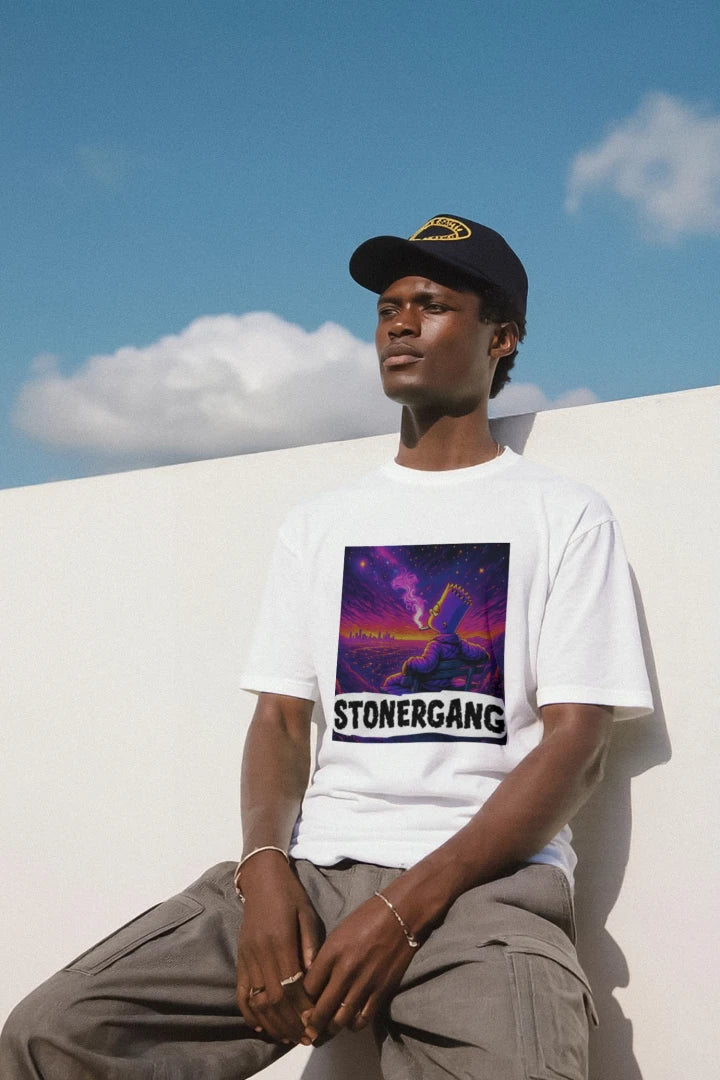 Young man wearing STONERKEY PASS D METHOD tee with vibrant graphic design, posing outdoors against a blue sky.